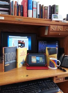 3 books and kindle on desktop