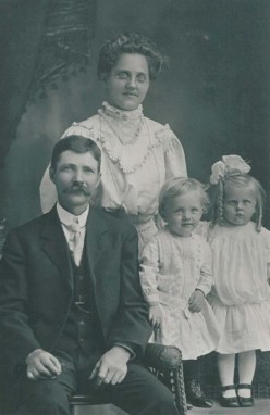 Grandma and Grandpa. The little girl scowling on the right is my mom. The happy little boy is Uncle Helmer.
