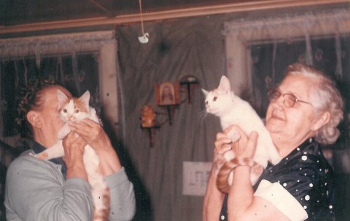 Eva and Grandma with their cats. Eva never liked to have her picture taken - that's why she's hiding behind her cat.